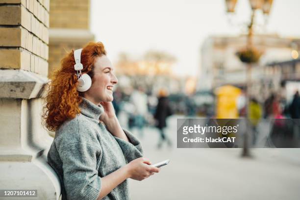 portret van een casusal jonge vrouw - luisteren stockfoto's en -beelden