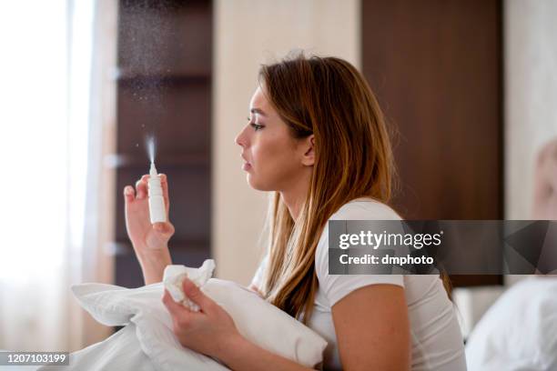 woman using nasal spray - human nose stock pictures, royalty-free photos & images