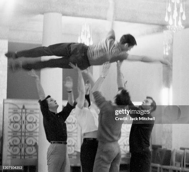 Dancer Dirk Sanders is held aloft during backstage rehearsals for Mary Martin's Easter Sunday live color telecast , 1959.