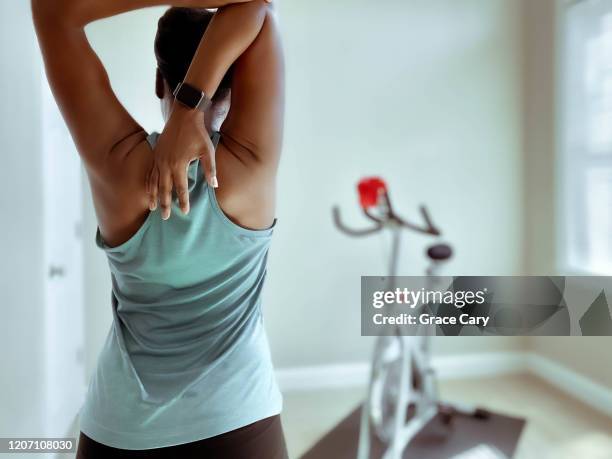 rear view of woman stretching after indoor cycling - back stretch stockfoto's en -beelden