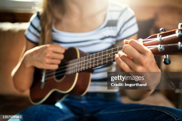 closeup of teenage girl playing ukulele - ukelele stock pictures, royalty-free photos & images