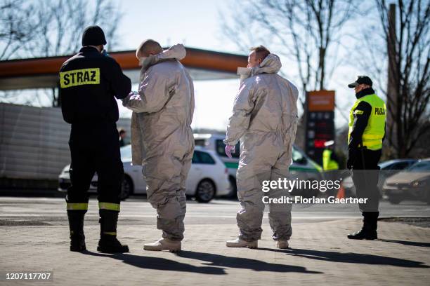 Border control guards, police officers and people in protective clothing check migrants on March 14, 2020 in Zgorzelec, Poland. Poland and Czech...