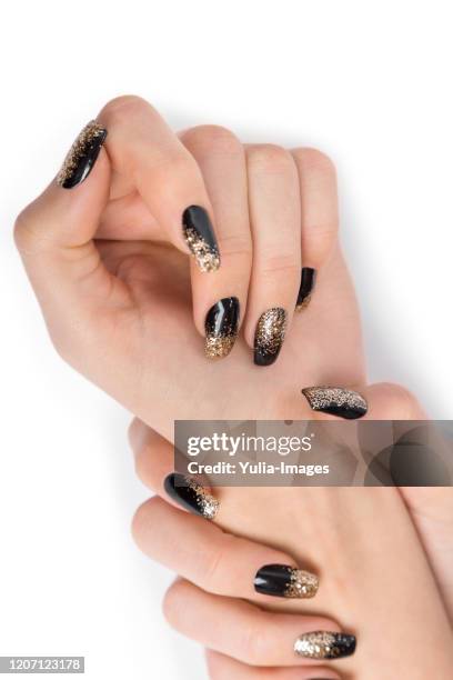 close up of stylish hands painted black and gold - enamel stockfoto's en -beelden