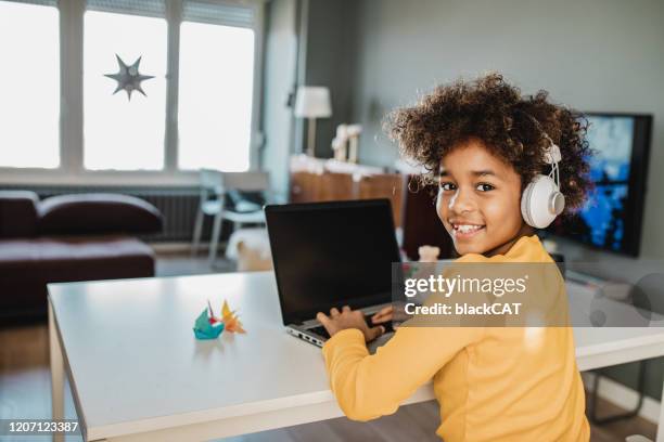 jong meisje dat met laptop thuis studeert - young girls homework stockfoto's en -beelden