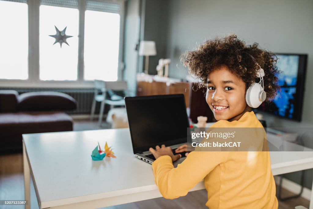 Young girl studying with laptop at home
