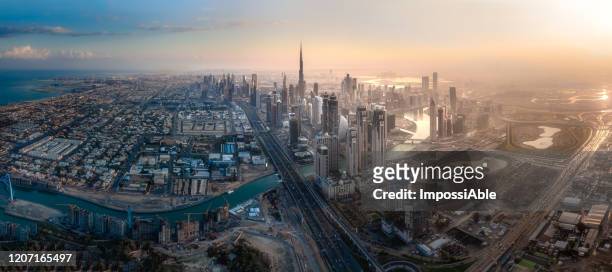 aerial panorama view of dubai cityscape with burj khalifa during morning sunrise - dubai skyline morning stock pictures, royalty-free photos & images