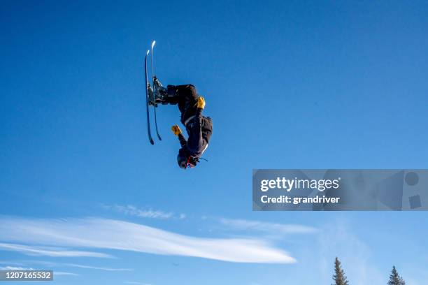 joven esquiador de estilo libre extremo masculino que viene de un salto al revés, con confianza en una zona de esquí en colorado - salto de espalda fotografías e imágenes de stock