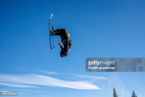 young male extreme freestyle skier coming off a jump upside down, with confidence at a ski area in colorado - backflipping imagens e fotografias de stock
