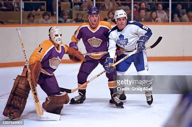 Mario Lessard and Jay Wells of the Los Angeles Kings skates against Wilf Paiement of the Toronto Maple Leafs during NHL game action on January 9,...