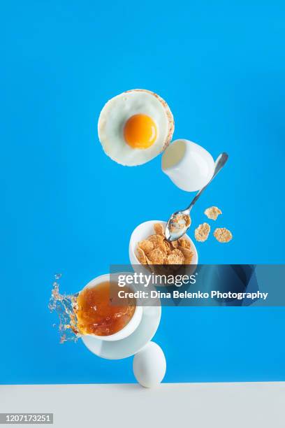 healthy breakfast with cereals and egg toast, balanced food on a vivid blue background with copy space - levitation stock-fotos und bilder