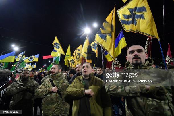 Ukrainian veterans of the war with Russia-backed separatists on the East of the country burn flires outside Russian embassy in Kiev on March 14, 2020...