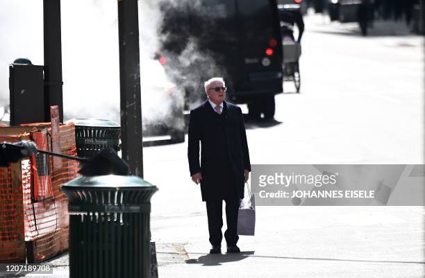 Man waits to cross a street in Manhattan on March 14, 2020 in New York City. - The World Health Organization said March 13, 2020 it was not yet...