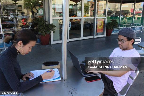 International students Yaqing "Victoria" Yang and Ende Shen of China study together at a sidewalk table in the Silicon Valley city of Palo Alto on...