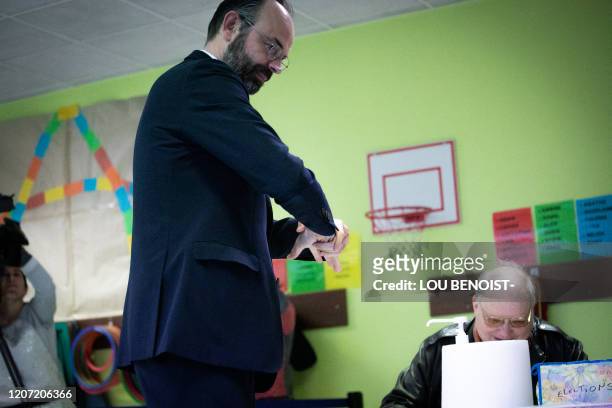 French Prime minister and candidate running as Le Havre's city mayor Edouard Philippe rubs his hands after casting his vote during the first round of...