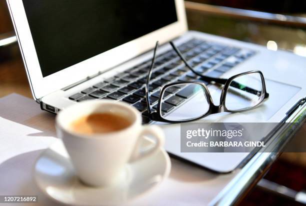 Picture taken on March 15, 2020 shows glasses on a laptop at a home office desk in Salzburg, Austria. / Austria OUT