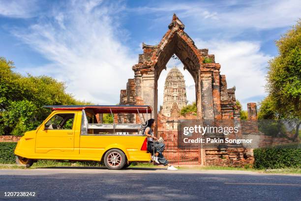 young asian female traveler with backpack traveling sitting on taxi or tuk tuk with old temple (wat mahathat) background - chang mai stock pictures, royalty-free photos & images