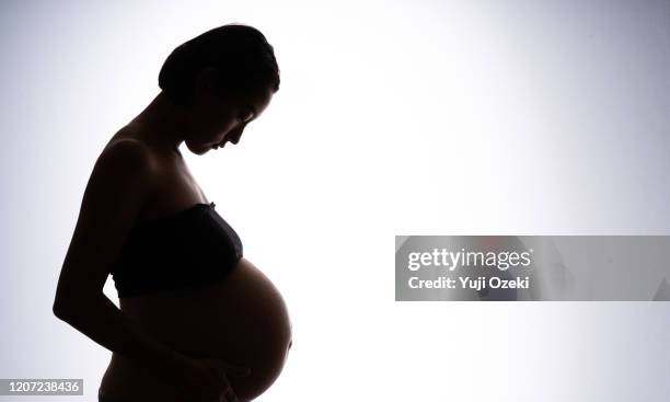 studio portrait of pregnant woman - male stomach stock-fotos und bilder