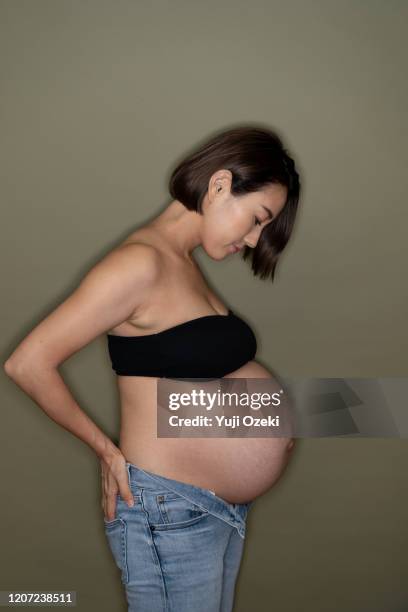 studio portrait of pregnant woman - guess jeans stock pictures, royalty-free photos & images