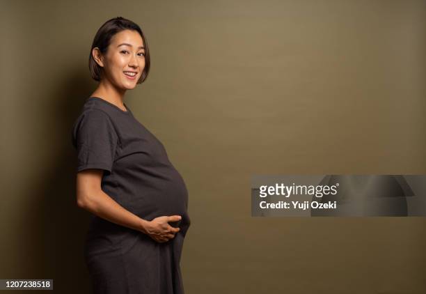 studio portrait of asian pregnant woman - rijzen stockfoto's en -beelden