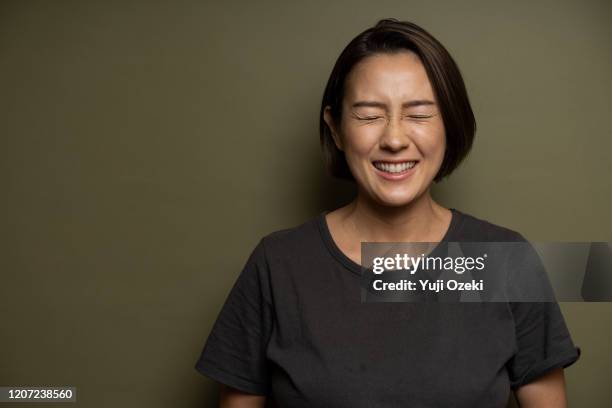 studio portrait of asian young adult woman - laughing woman ストックフォトと画像