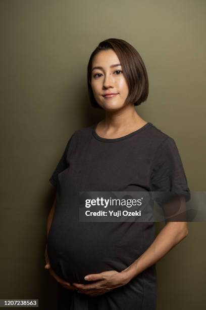 studio portrait of asian pregnant woman - bulging belly stock pictures, royalty-free photos & images