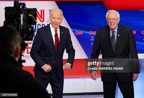 Democratic presidential hopefuls former US vice president Joe Biden and Senator Bernie Sanders smile after an elbow greeting before the start of the...
