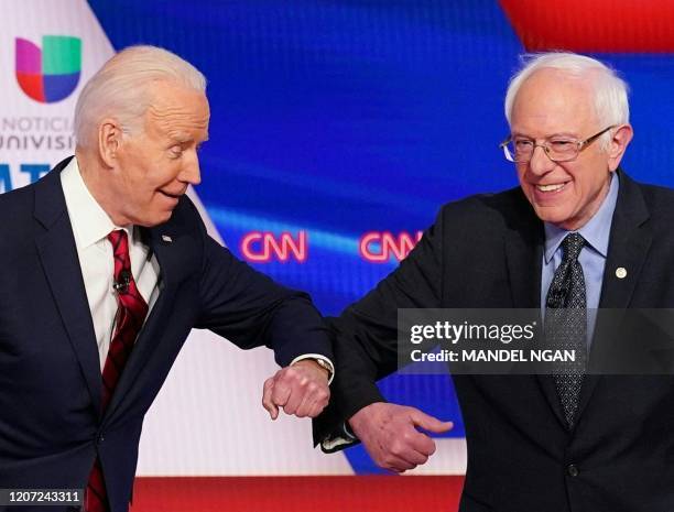 Democratic presidential hopefuls former US vice president Joe Biden and Senator Bernie Sanders greet each other with a safe elbow bump before the...