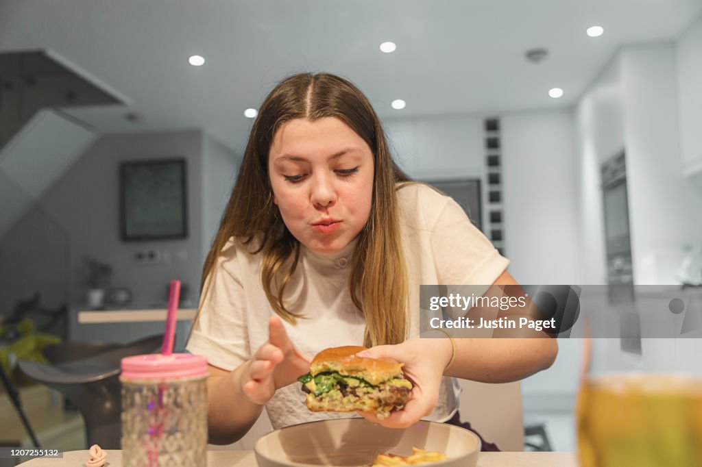 Teenage girl loving that burger...yummm!