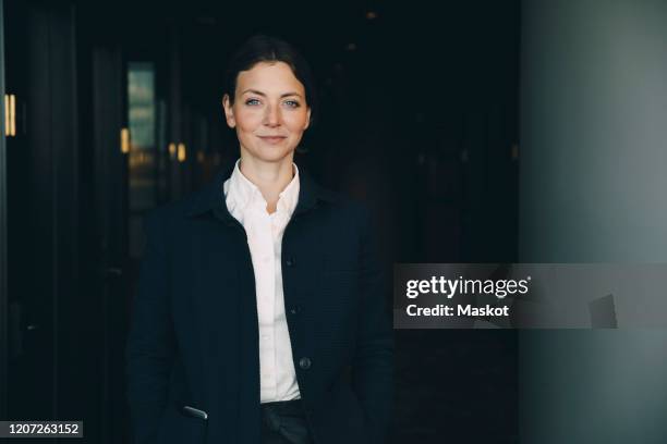 portrait of confident female entrepreneur standing in corridor at workplace - one woman only 35-40 stock pictures, royalty-free photos & images