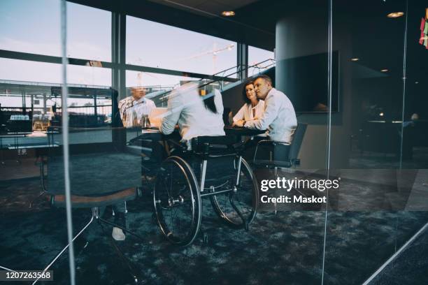 male and female entrepreneurs planning strategy during meeting in board room at creative office - disability working stockfoto's en -beelden