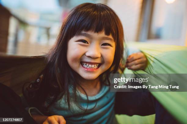lovely little girl smiling at the camera while playing joyfully in hammock - hong kong girl stock-fotos und bilder