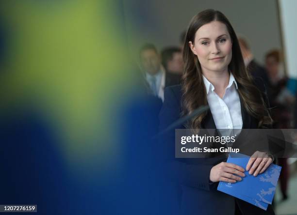 Finnish Prime Minister Sanna Marin and German Chancellor Angela Merkel arrive to speak to the media following talks at the Chancellery on February...