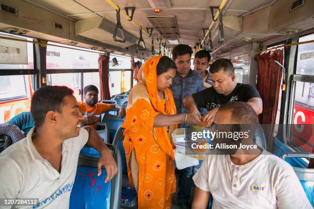 Shanaz collects empty lunch boxes she sold to drivers at a bus stop on March 9, 2020 in Dhaka, Bangladesh. Dhrubotara, which means "the star never...