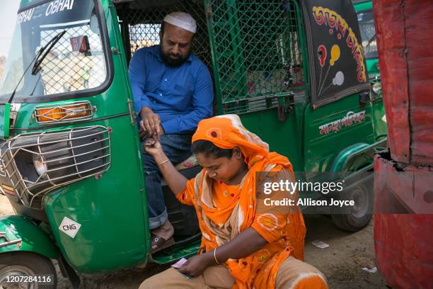 Shanaz collects payment from a rickshaw driver at a bus stop on March 9, 2020 in Dhaka, Bangladesh. Dhrubotara, which means "the star never stops...