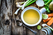 Vegetables broth with ingredients shot on rustic kitchen table. Copy space