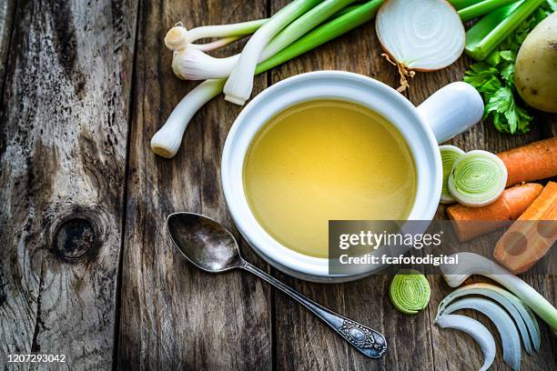 vegetables broth with ingredients shot on rustic kitchen table. copy space - broth stock pictures, royalty-free photos & images