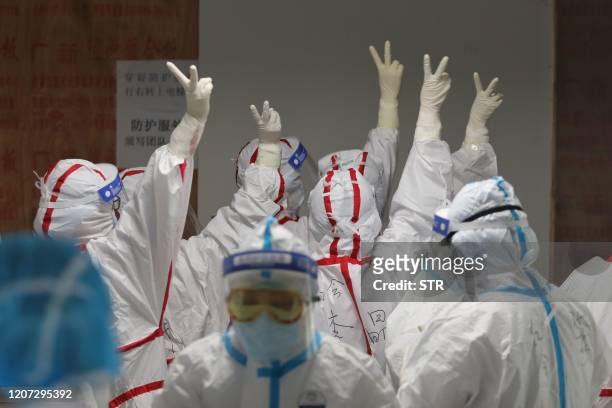 Medical staff cheer themselves up before going into an ICU ward for COVID-19 coronavirus patients at the Red Cross Hospital in Wuhan in China's...