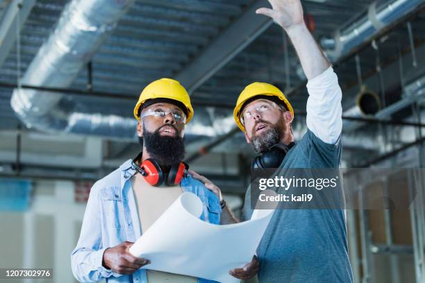two construction workers in building with plans - duct stock pictures, royalty-free photos & images