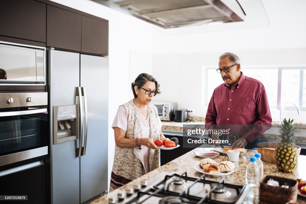 Senior married couple eating healthy food for breakfast.