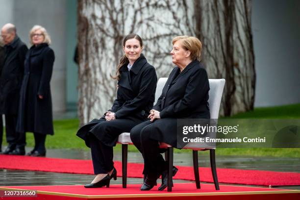 German Chancellor Angela Merkel and new Finnish Prime Minister Sanna Marin listen to the national anthems at the Chancellery on February 19, 2020 in...