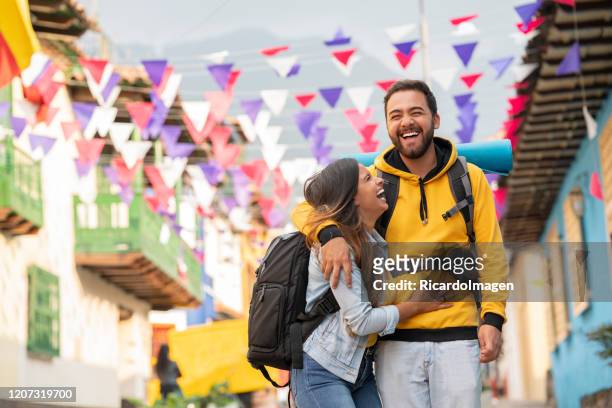 pareja latina abrazándose mientras viaja por la ciudad - turista fotografías e imágenes de stock