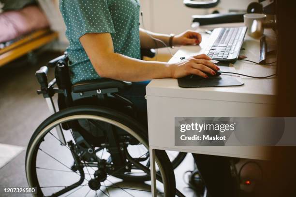 midsection of young disabled woman using computer at home - arabic keyboard fotografías e imágenes de stock