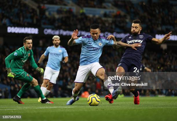 Gabriel Jesus of Manchester City holds off Ryan Fredericks of West Ham United during the Premier League match between Manchester City and West Ham...