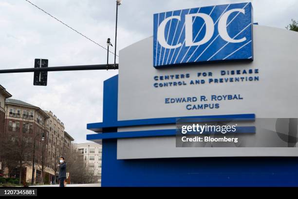 Pedestrian wearing a protective face mask walks past the Centers for Disease Control and Prevention headquarters in Atlanta, Georgia, U.S, on...