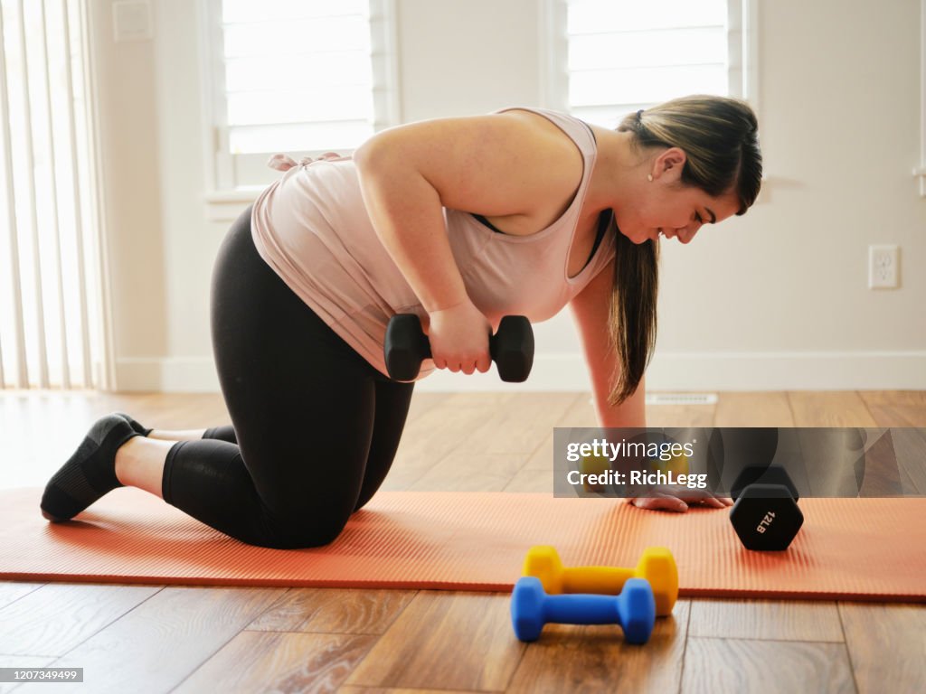 Mujer usando pesas de ejercicio en un hogar