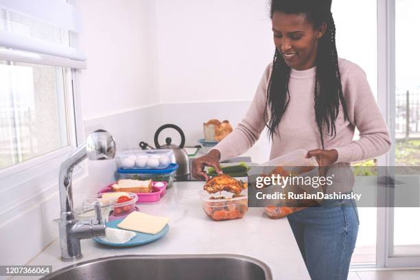 woman packing leftovers. - chicken ingredient stock pictures, royalty-free photos & images