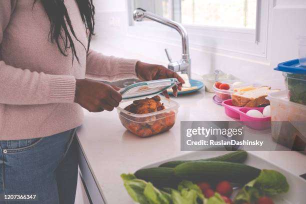 una mujer guardando comida de sobras. - frugalidad fotografías e imágenes de stock