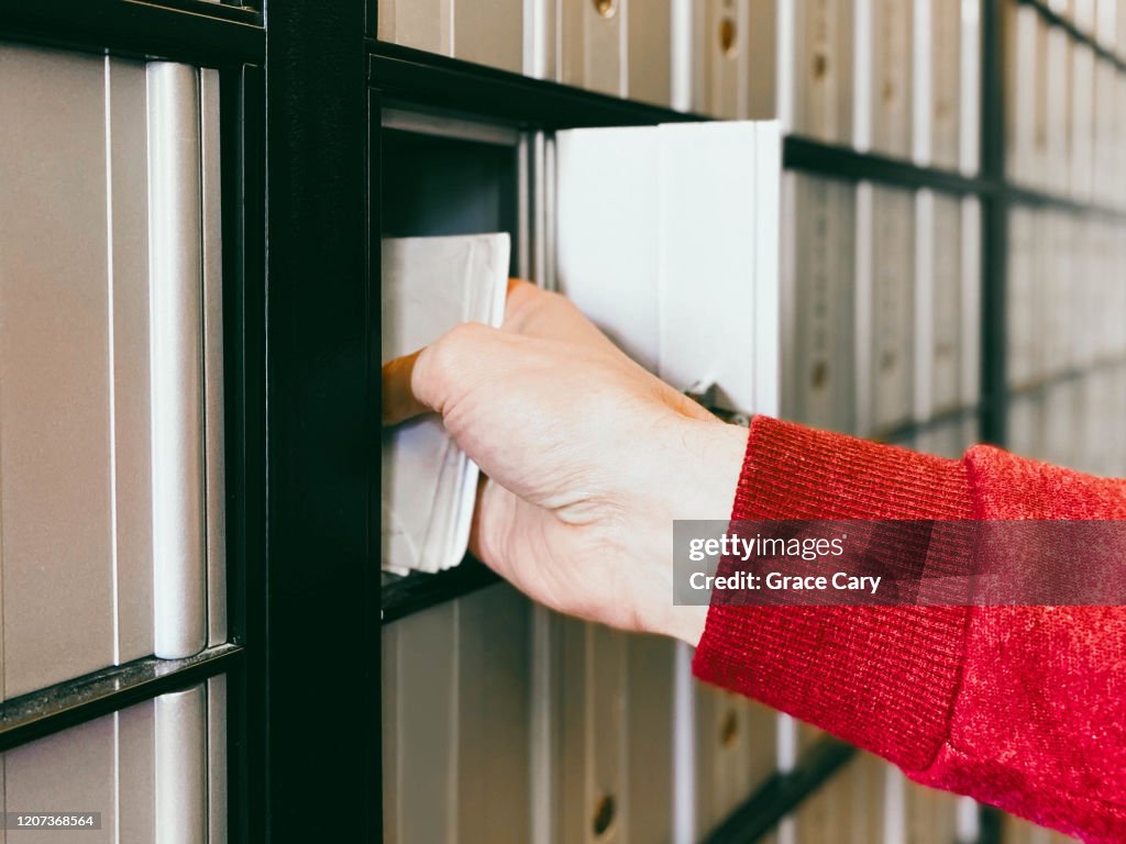 Close-Up of Man Picking Up Mail from Post Office Box