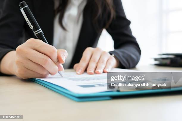 business woman signing the contract to conclude a deal in modern office. - deal signing stockfoto's en -beelden