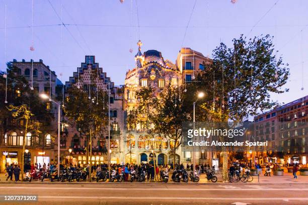 passeig de gracia at dusk with illuminated buildings, barcelona, spain - ガウディ ストックフォトと画像